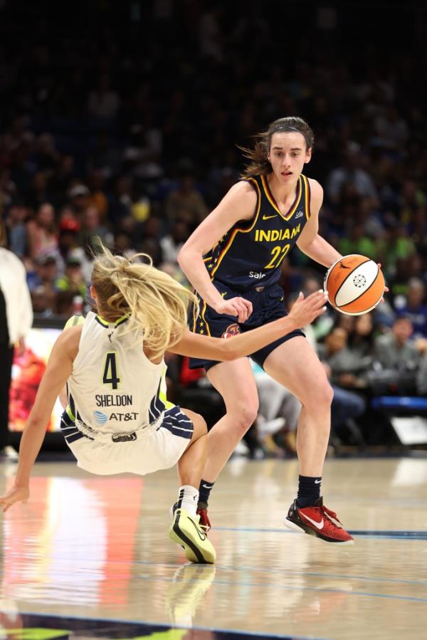 Caitlin Clark #22 of the Indiana Fever drives against Jacy Sheldon #4 of the Dallas Wings at College Park Center on May 03, 2024 in Arlington, Texas.  