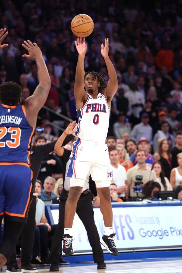 Philadelphia 76ers guard Tyrese Maxey (0) hits a shot over New York Knicks center Mitchell Robinson (23) in overtime.  