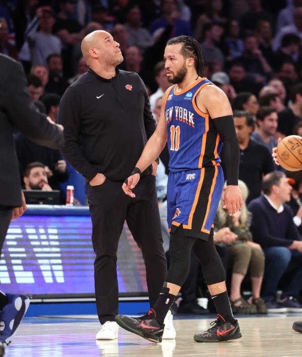 New York Knicks guard Jalen Brunson (11) walks back to the bench past his father assistant coach Rick Brunson in overtime. 