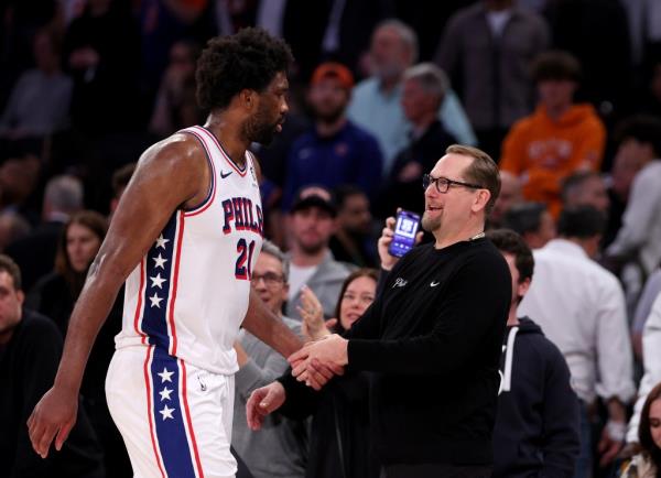 Joel Embiid #21 of the Philadelphia 76ers heads for the bench as he is greeted by Nick Nurse in overtime of Game 5. 