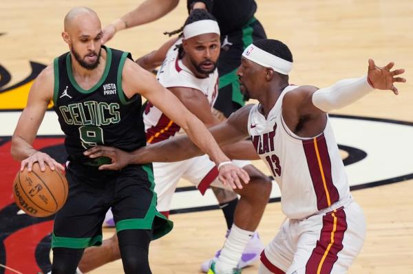 Celtics guard Derrick White dribbles as Heat center Bam Adebayo defends during the second half in Miami.