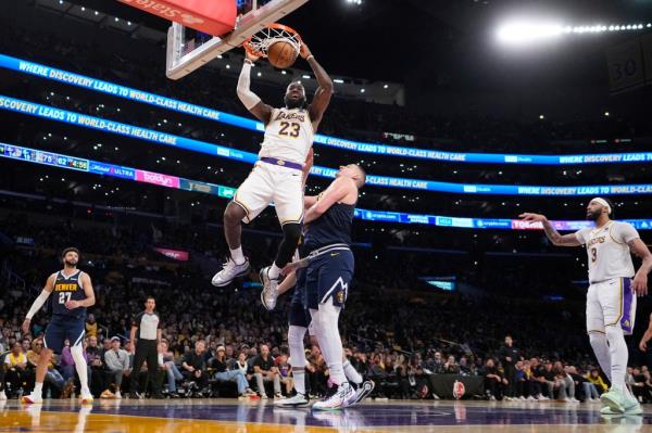 Los Angeles Lakers forward LeBron James (23) dunks as Denver Nuggets center Nikola Jokic (15) defends during the second half in Game 4 of an NBA basketball first-round playoff series Saturday, April 27, 2024, in Los Angeles.  